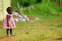 toddler african black girl holding a stick in a dress