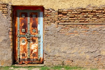 Old rusted vault door in weathered brick wall