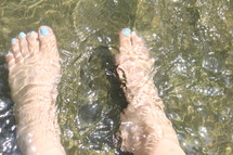A woman's feet in a river.