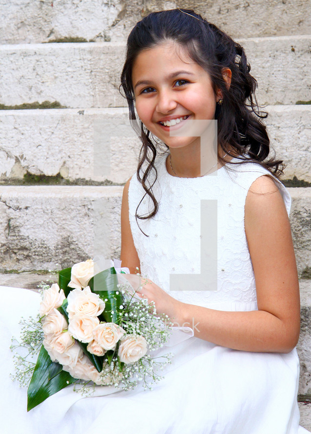 Smiling young girl in white dress for First Communion