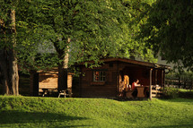 woman sitting at a picnic table in front of a cabin 