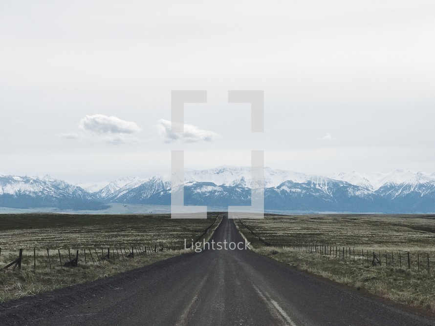 rural road and snow capped mountains 