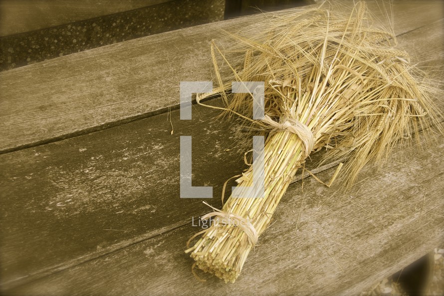 Bundle of wheat on old wooden table