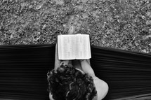 a woman on a hammock reading a Bible 