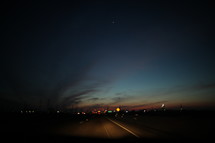 distant city lights at night from a highway 
