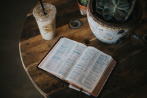 open Bible and iced coffee on a table 