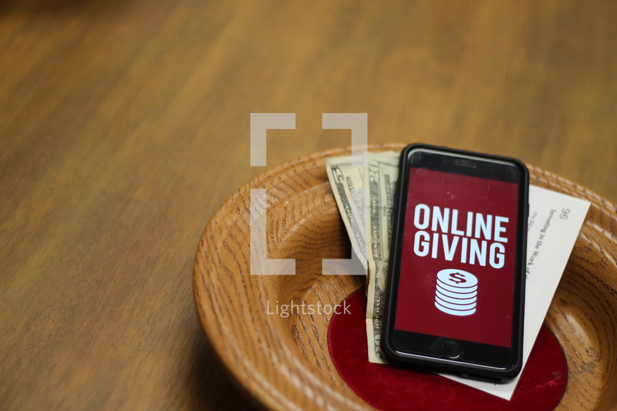 offering plate with a cellphone with an online giving app on the screen 