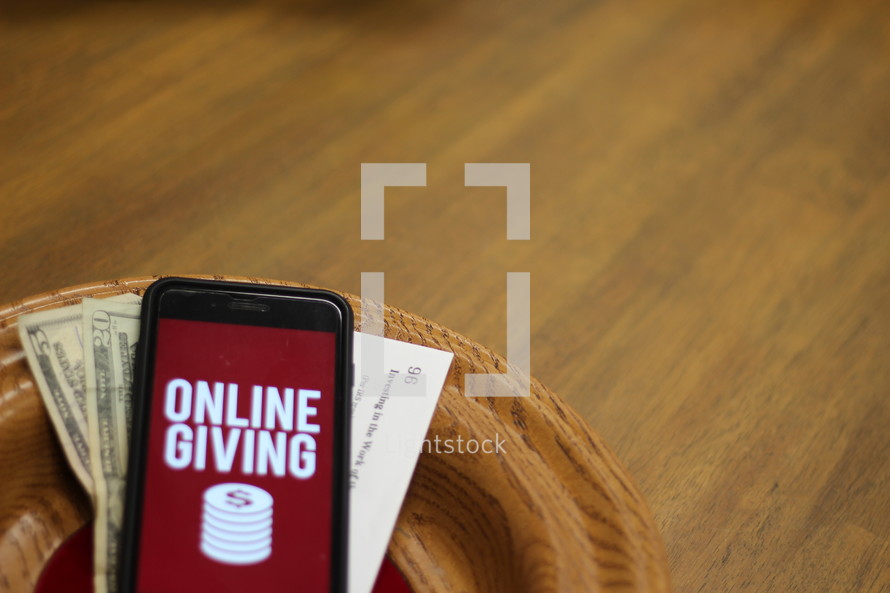 cellphone with an online giving app in an offering plate 