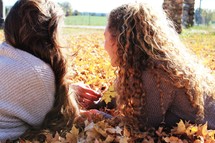 girls in a fall leaves 