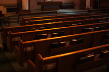 hymnals and Bible in the back of church pews 