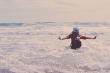 a girl jumping in the waves 