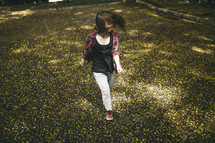 teen girl walking through a field of wildflowers 