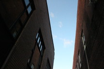 looking up between two brick buildings