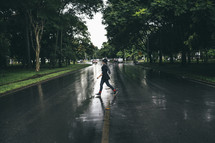 A young woman walking across a wet street.