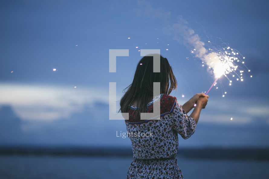 woman holding a sparkler outdoors 