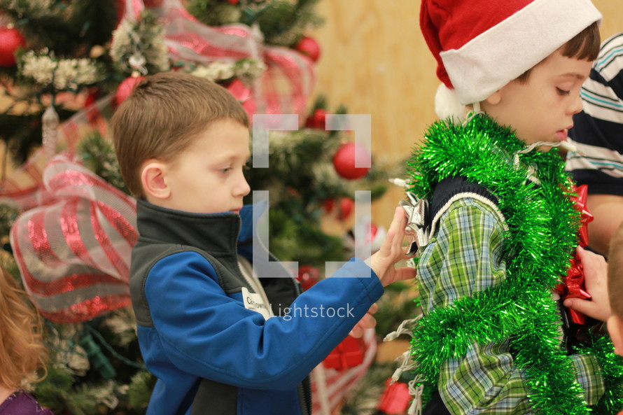 Boys wearing Christmas decorations.