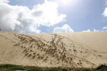 A sand dune covered in footprints.