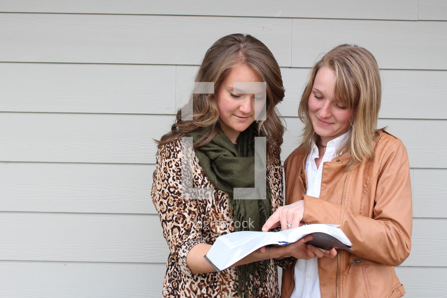 Two women looking at a Bible together.