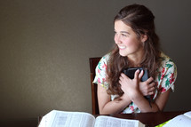 A smiling girl holding a Bible.