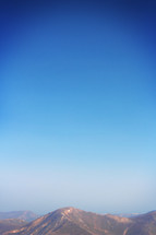 mountain peak and haze in a blue sky 