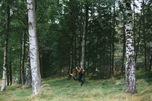 a woman dancing in a forest 