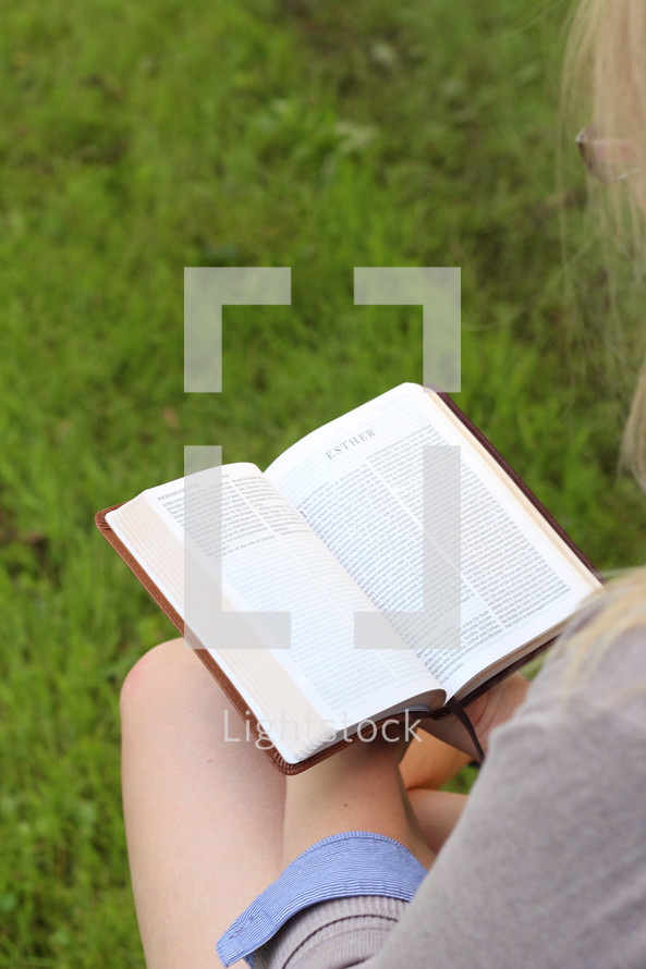 woman reading a Bible outdoors 