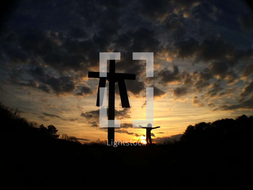 silhouette of a cross with a shroud and girl with open arms 