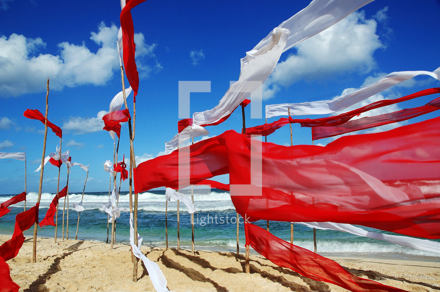 red and white banners waving on a beach 