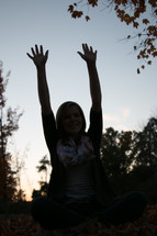 silhouette of a woman with raised arms 