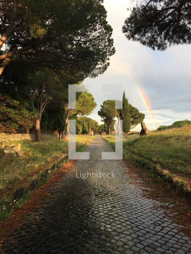 rainbow over a cobblestone road 