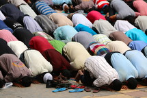 Muslim men bow in prayer at a city mosque