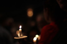 holding candles at a Christmas Eve service 