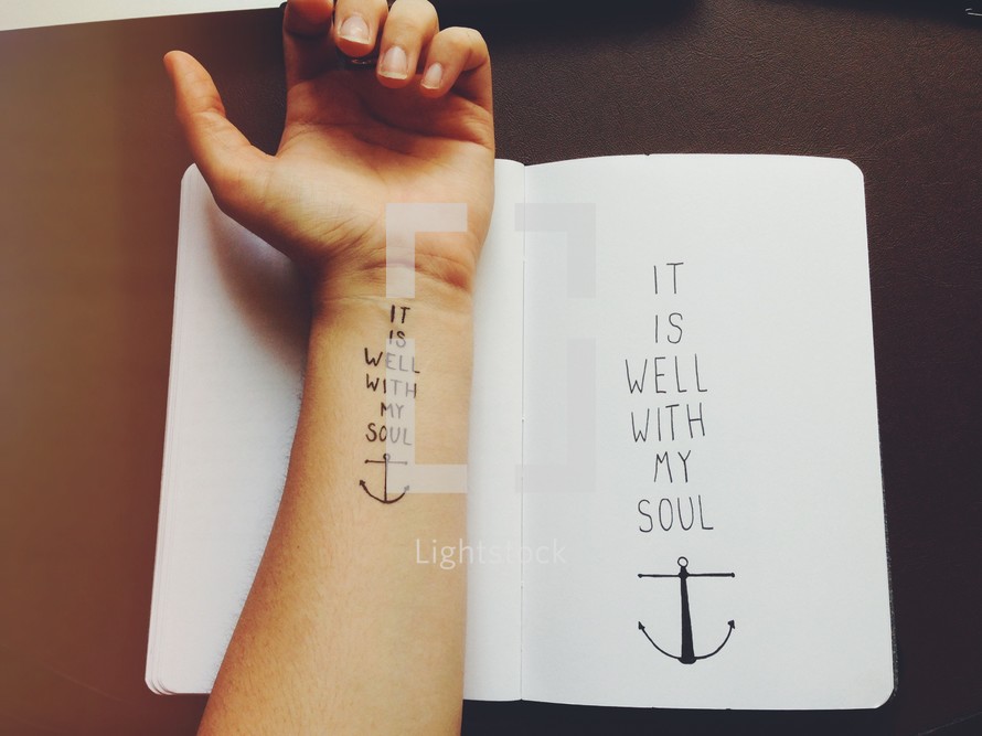 Arm tattoo and and journal -- "it is well with my soul."