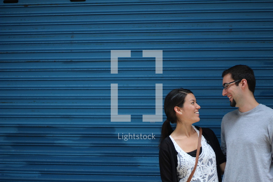 a couple talking in front of a blue wall 