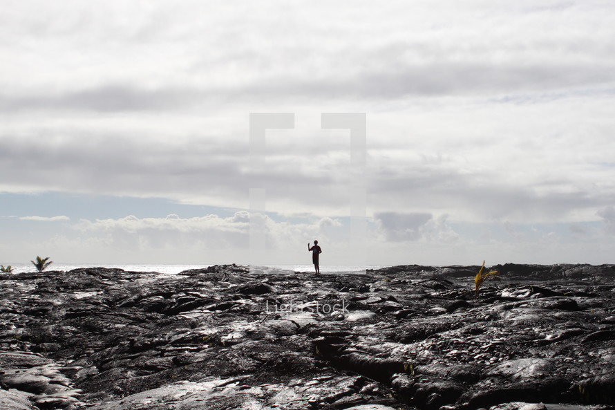 a man standing on volcanic ash