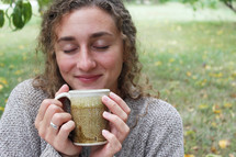 smiling woman holding a mug of coffee 