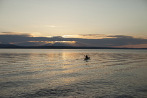 a man rowing a kayak at sunset 
