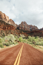 road in a national park and red rock peaks 