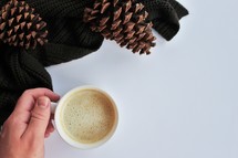 latte, pine cones, and knit scarf 