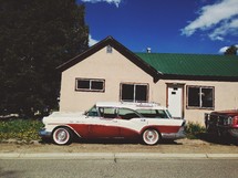 vintage station wagon in front of a house 