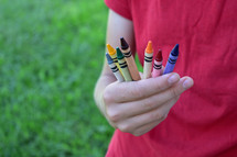 kid holding crayons 