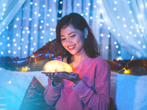 a smiling woman holding a glowing book 