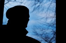 silhouette of a man in a wool cap outdoors 