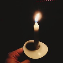 Man holding a candle at a Christmas eve service. 