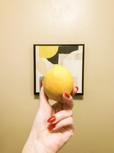 a woman holding up a lemon 