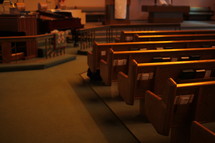 hymnals and bibles in the back of pews in an empty church 