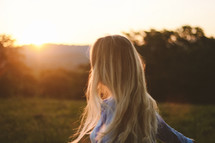 Women looking at the sunset on a filed