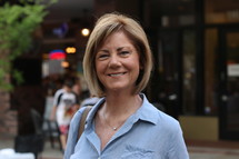 face of a woman standing outdoors in a blue shirt 