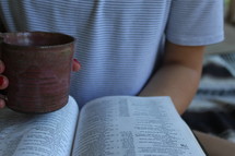 a girl reading a Bible and drinking coffee 