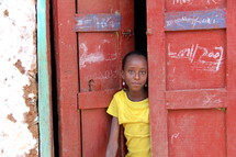 Young girl looking out of a door in Ethiopia, Africa